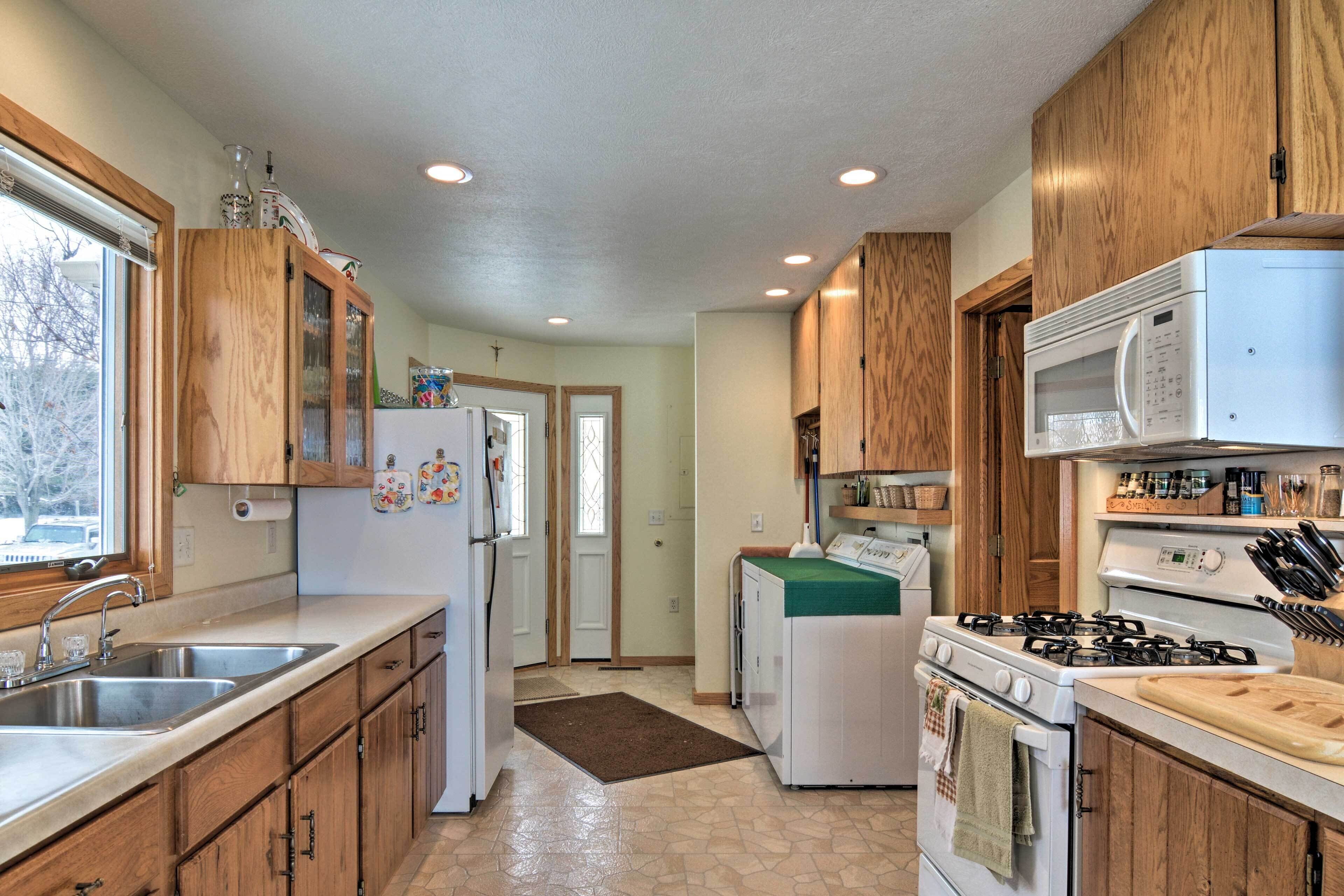 A kitchen with wooden cabinets, a refrigerator, a stove, and a microwave.