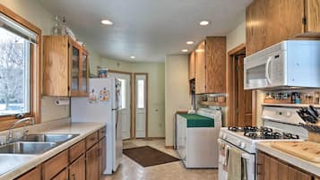A kitchen with wooden cabinets, a refrigerator, a stove, and a microwave.