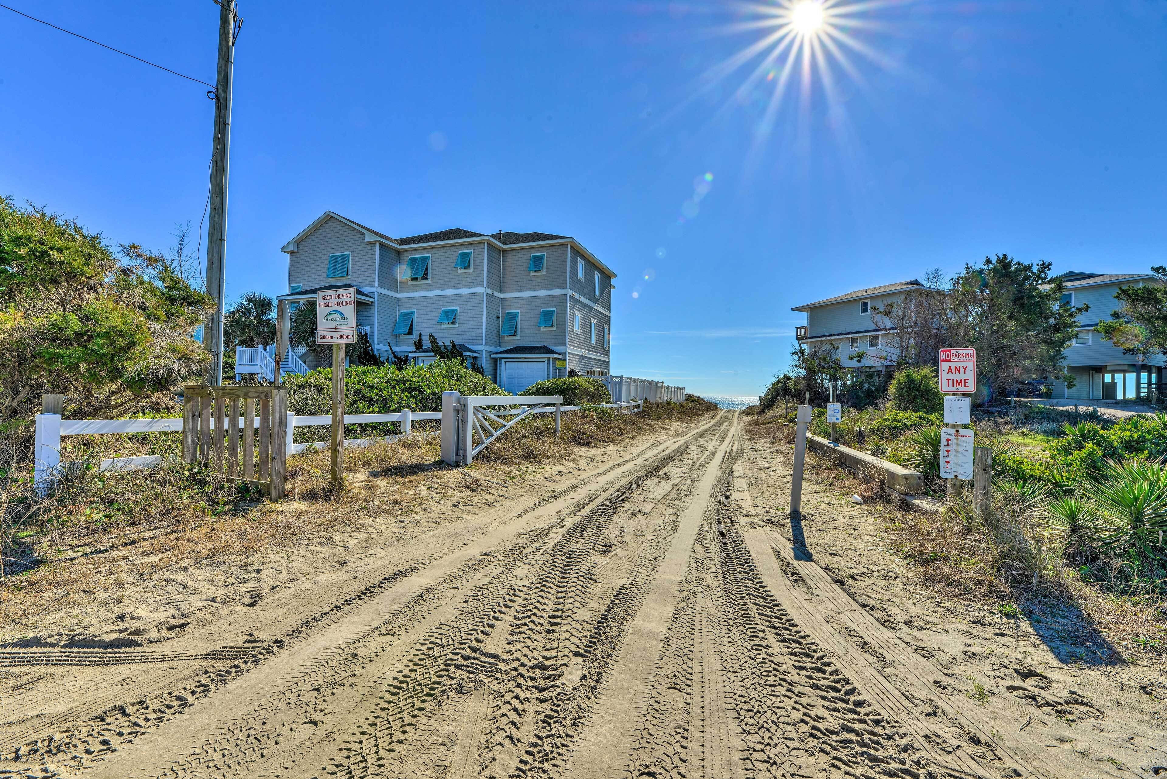 A coastal road leading to a multi-story building with a 'No Parking - Any Time' sign.