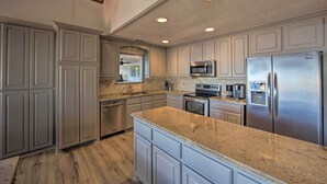 A modern kitchen with granite countertops, stainless steel appliances, and white cabinetry. - Stunning Lakefront Home: Hot Tub & Game Room! (Mabank)