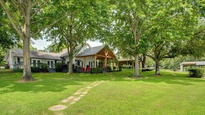 A well-maintained lawn with a stone pathway leading to a house with a porch. - Stunning Lakefront Home: Hot Tub & Game Room! (Mabank)