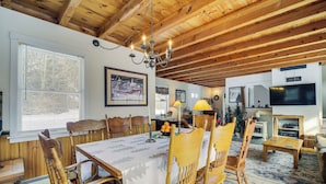 A dining area with a wooden table and chairs, a chandelier, and a fireplace. - 4 Mi to Sugarbush Resort: Waitsfield Retreat (Waitsfield)