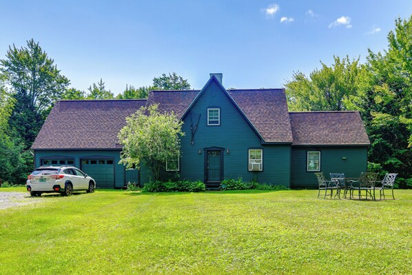 A two-story house with a dark green exterior, a sloped roof, and a front porch with chairs. - 4 Mi to Sugarbush Resort: Waitsfield Retreat (Waitsfield)