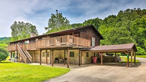 A two-story wooden cabin with a balcony, stone foundation, and a covered porch. - Richwood Respite Near Trout Fishing (Richwood)