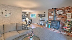Uma sala de estar com lareira de tijolos, um relógio e um letreiro com a palavra 'HOME'.