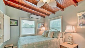 Ein Schlafzimmer mit einem Bett, Nachttischlampen, einem kleinen Tisch und einem Deckenventilator.