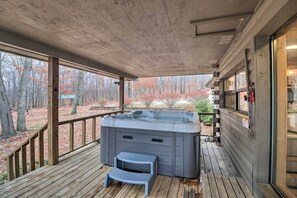 A hot tub on a wooden deck with a view of a forest. - Charming Cabin w/ Hot Tub, Fire Pit & Views! (Jasper)