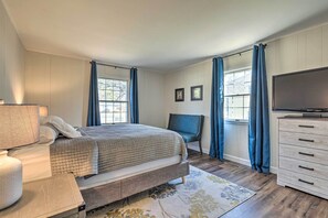 A bedroom with a bed, a chair, a dresser, a television, and a window with curtains. - Waterfront Retreat < 4 Mi to Dtwn Cambridge! (Cambridge)