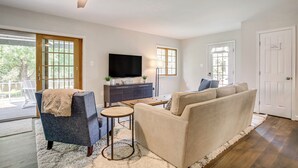 A living room with a sofa, armchair, TV, and wooden coffee table. - Waterfront Retreat < 4 Mi to Dtwn Cambridge! (Cambridge)