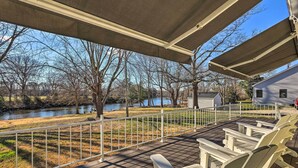 A covered deck with Adirondack chairs overlooking a river and a house. - Waterfront Retreat < 4 Mi to Dtwn Cambridge! (Cambridge)