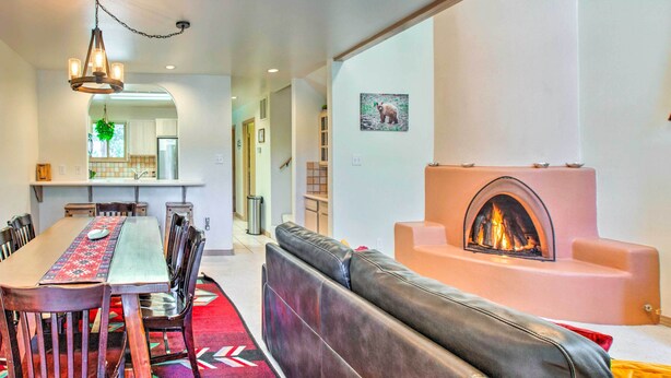 Ein modernes Wohnzimmer mit Kamin, einem Essbereich mit langem Tisch und Stühlen sowie einer gemütlichen Sitzecke mit einer Couch.