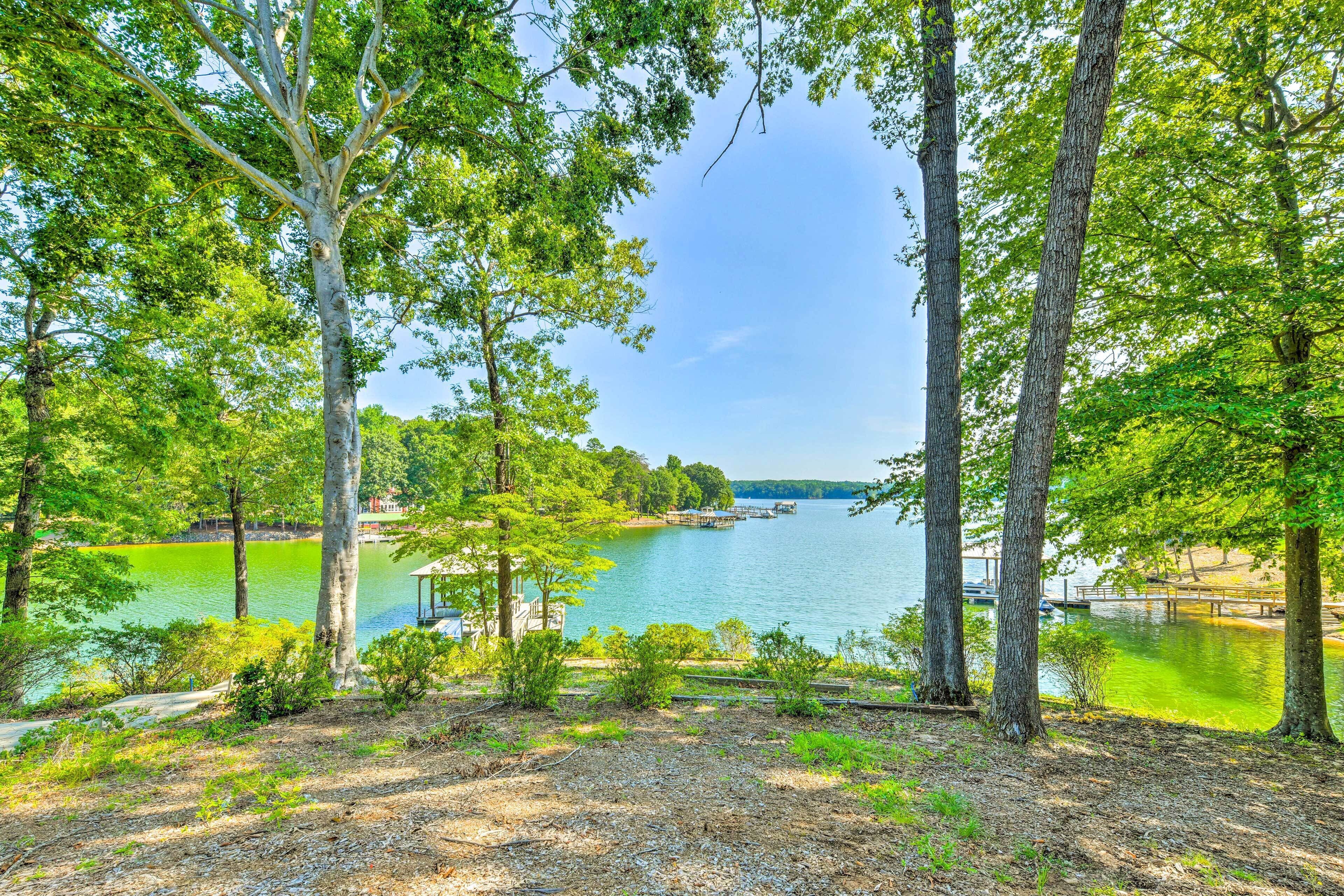 Vista di un lago con alberi, un molo e un gazebo.