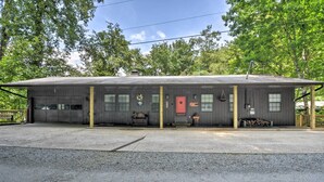 A single-story building with a garage, a covered porch, and a red door. - Nantahala Lake Family Home w/ Private Dock & Views (Topton)