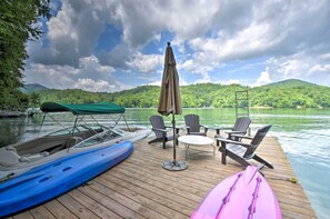 A wooden dock with a table and chairs, a covered boat, and a kayak. - Nantahala Lake Family Home w/ Private Dock & Views (Topton)