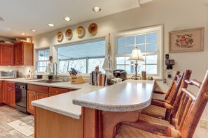 A kitchen with wooden cabinets, a granite countertop, and a large window. - Nantahala Lake Family Home w/ Private Dock & Views (Topton)