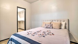 Een slaapkamer met een bed, een kledingkast en een plafondventilator.
