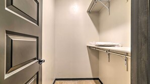 Een kleine, smalle badkamer met een deur, een handdoekhouder en een toilet.