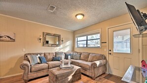 A living room with a sectional sofa, a coffee table, a mirror, and a door with a window. - 'hidden Oaks' Broken Bow Vacation Rental, Pets OK! (Broken Bow)