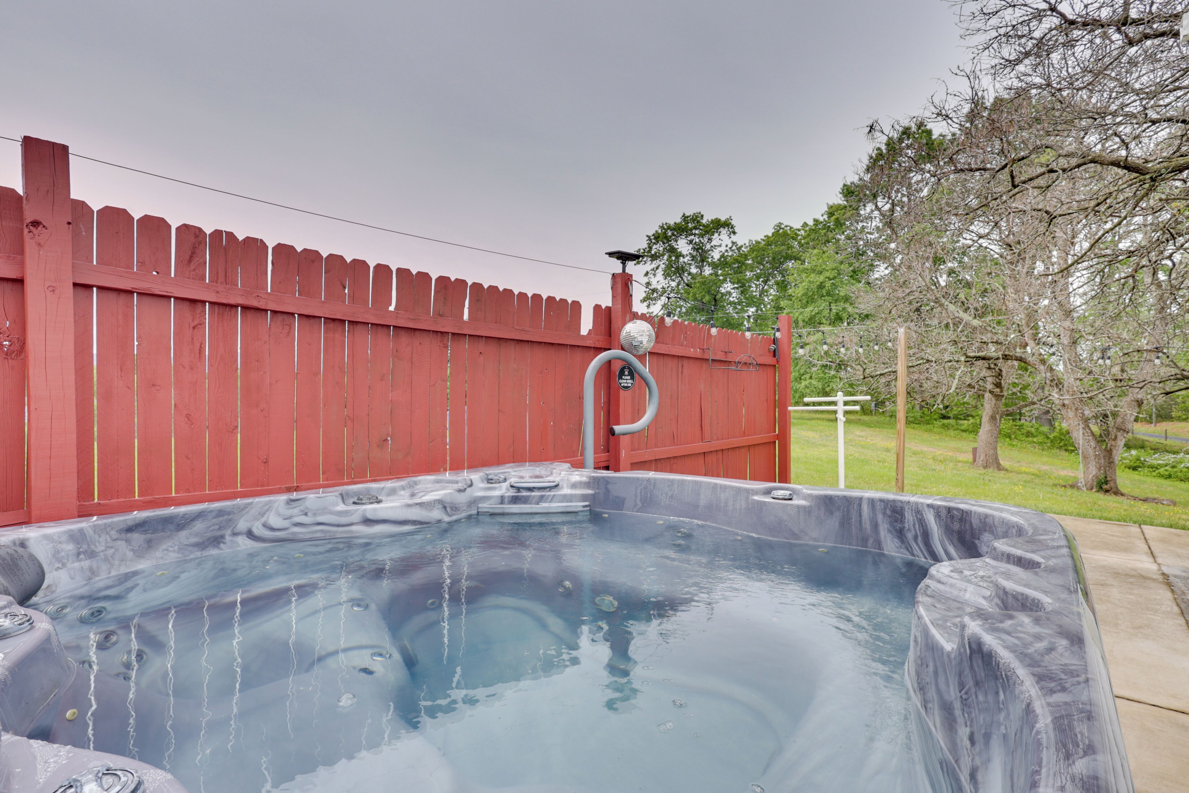 Un bain à remous avec une clôture rouge en arrière-plan.