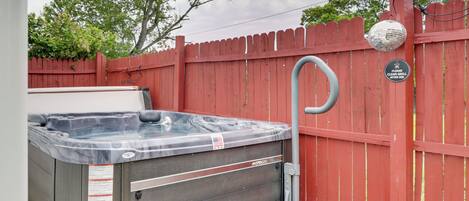 A hot tub with a built-in bench, a red fence, and a disco ball.