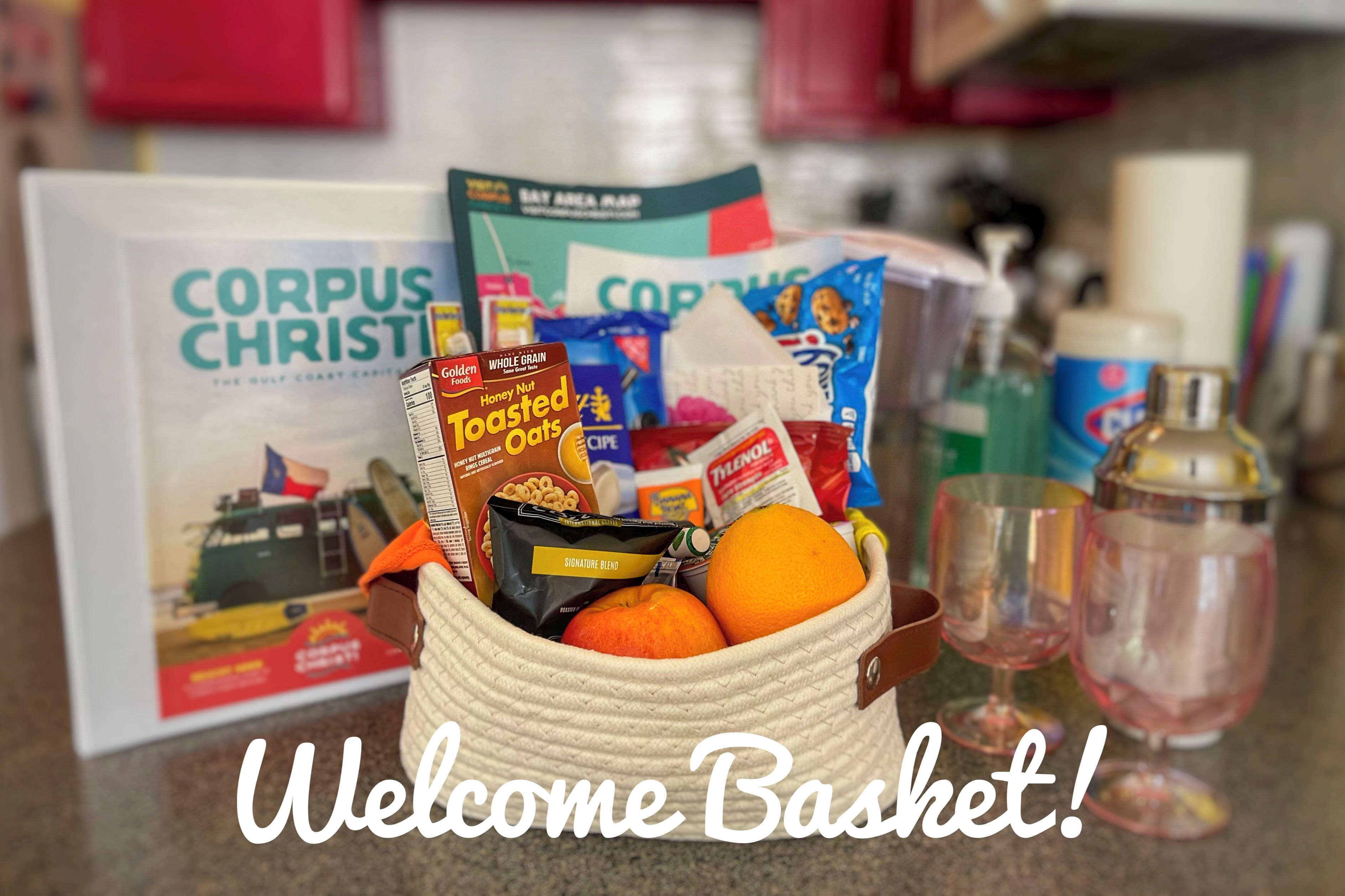 A basket filled with groceries and a book titled "Corpus Christi" on a kitchen counter.
