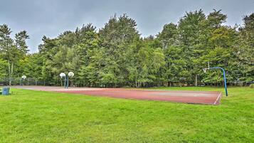 An outdoor basketball court surrounded by trees.