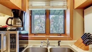 A kitchen with a double sink, a coffee maker, and a knife block. - 1/2 Mi to Sugar Mtn Resort: Condo w/ Balcony (Banner Elk)