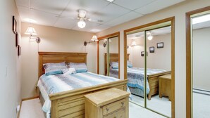 A bedroom with a wooden bed, bedside tables, a mirror, and ceiling lights. - 1/2 Mi to Sugar Mtn Resort: Condo w/ Balcony (Banner Elk)