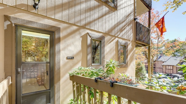 A wooden building with a glass door, a balcony with plants, and a flag. - 1/2 Mi to Sugar Mtn Resort: Condo w/ Balcony (Banner Elk)