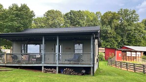 A two-story building with a balcony, a covered porch, and a fenced yard. - 5 Mi to Downtown Morganton: Cabin on Horse Farm (Morganton)