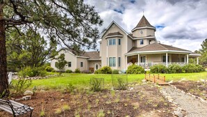 A large, two-story house with a wrap-around porch, a tower, and a well-maintained front yard with a bench and a wooden bridge. - Cozy Buena Vista Apartment < 4 Mi to Main Street! (Buena Vista)