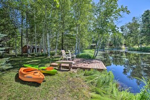 A serene lakeside setting with a wooden dock, kayaks, and a small cabin. - Atlanta Waterfront Cabin w/ Dock & Kayaks! (Atlanta)