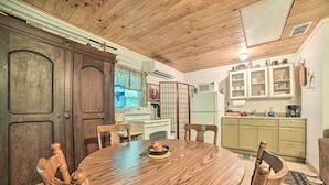 A wooden dining table with chairs, a kitchen area with cabinets, a stove, and a refrigerator. - Private Murray Abode w/ Fire Pit: Hunt & Fish (Murray)