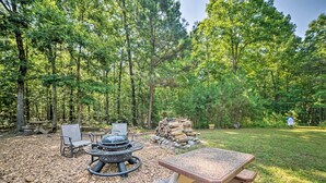 An outdoor seating area with a fire pit, chairs, and a table in a forested setting. - Private Murray Abode w/ Fire Pit: Hunt & Fish (Murray)