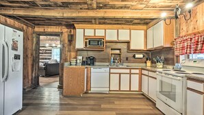 A kitchen with wooden cabinets, a microwave, a stove, and a dishwasher. - New Paris Cabin ~ 11 Mi to Shawnee State Park (New Paris)
