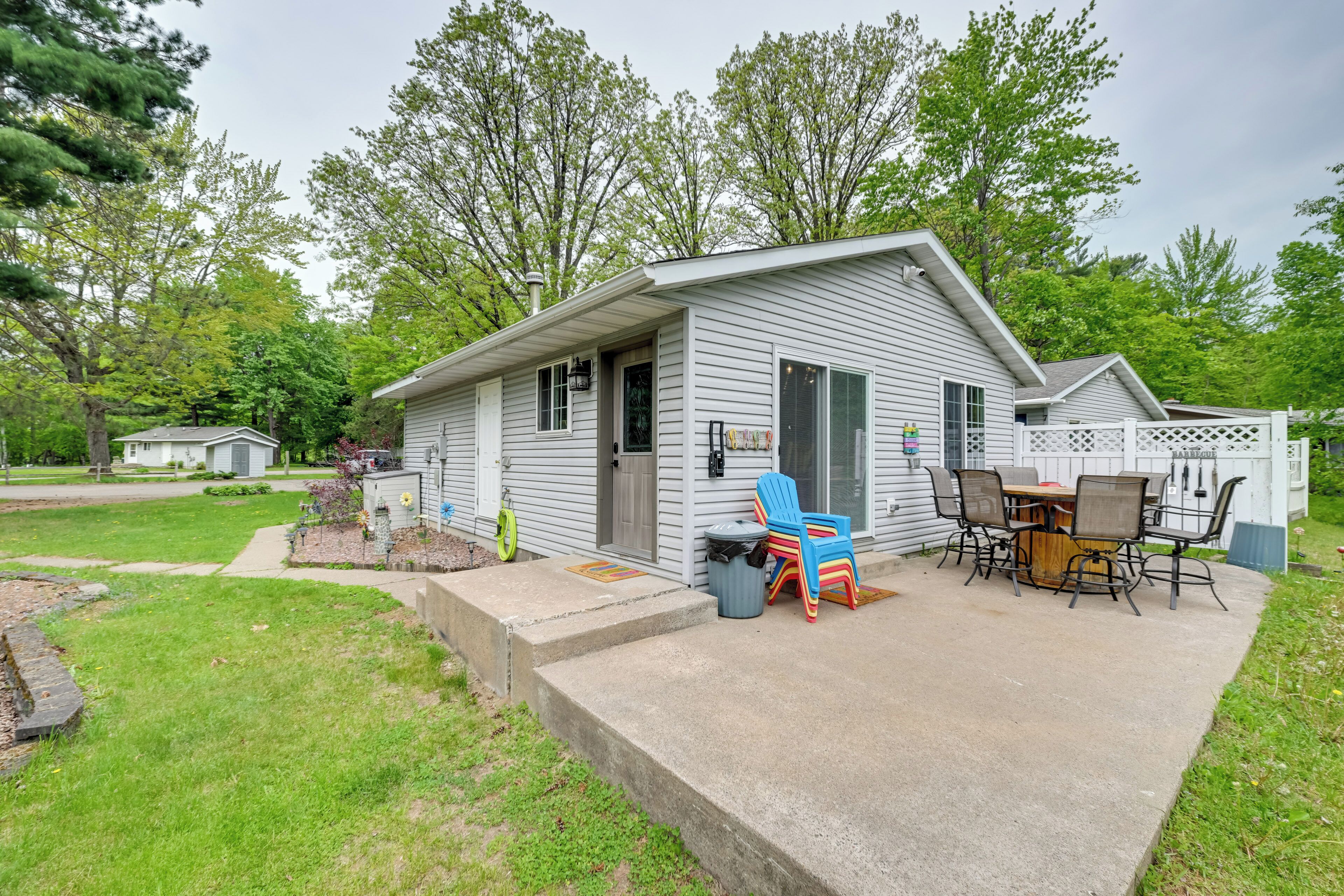 A single-story house with a patio area, a small deck, and a fenced backyard.