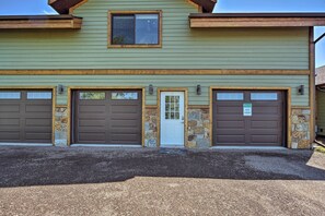 A two-story building with three garage doors, a stone accent wall, and a welcome sign. - Duluth Studio w/ Sauna on Working Horse Farm! (Duluth)
