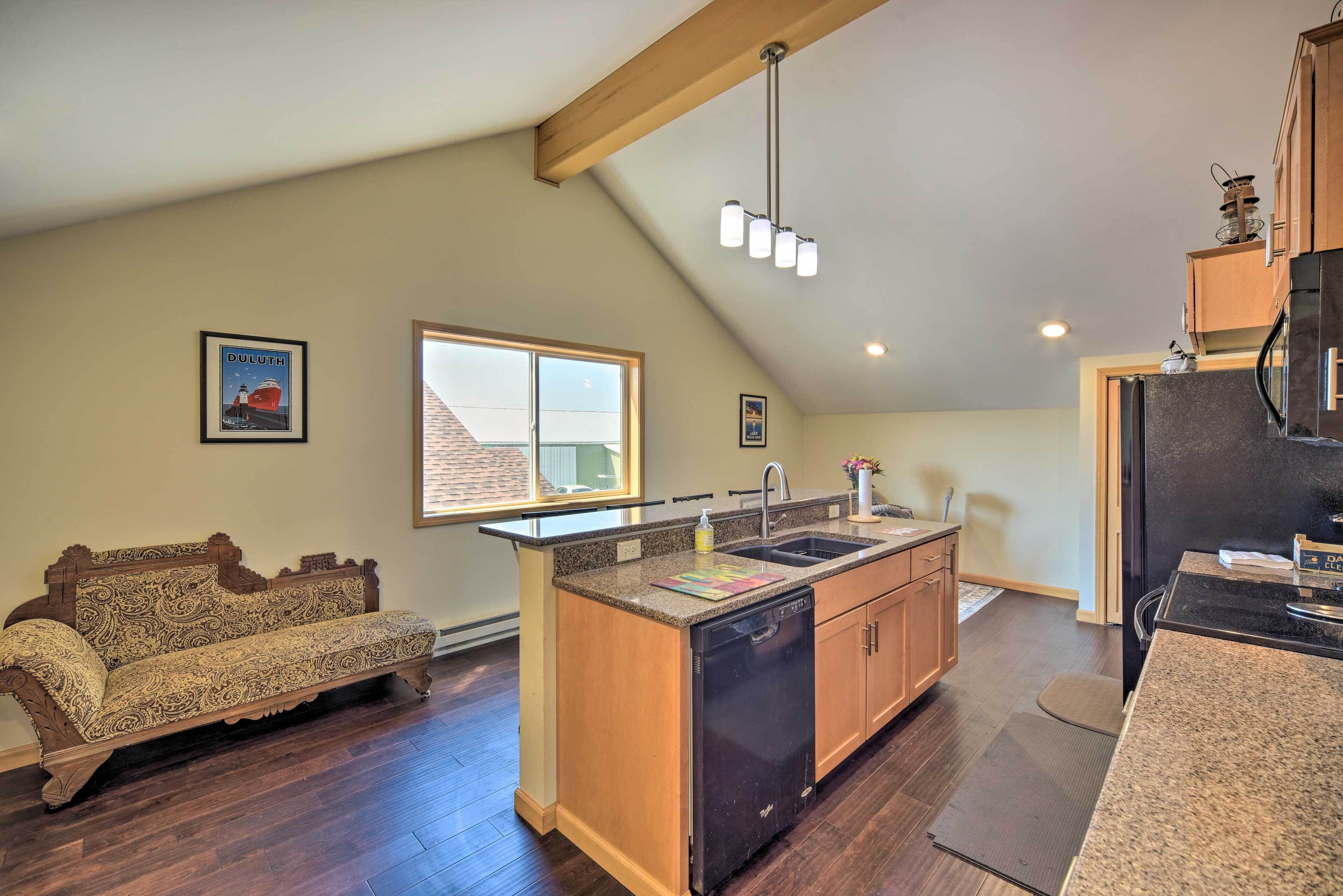 A kitchen with a built-in island, wooden cabinets, and a dishwasher.