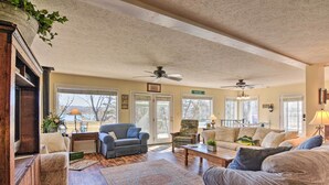 A spacious living room with a high ceiling, multiple seating areas, and large windows. - Lakefront Table Rock Getaway w/ Private Swim Dock! (Golden)