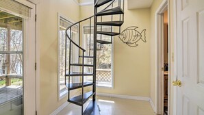 A spiral staircase in a hallway with a fish mural on the wall. - Lakefront Table Rock Getaway w/ Private Swim Dock! (Golden)