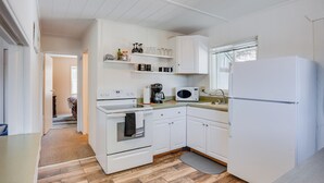 Une cuisine moderne avec des meubles blancs, un four encastré, un four à micro-ondes et un réfrigérateur.