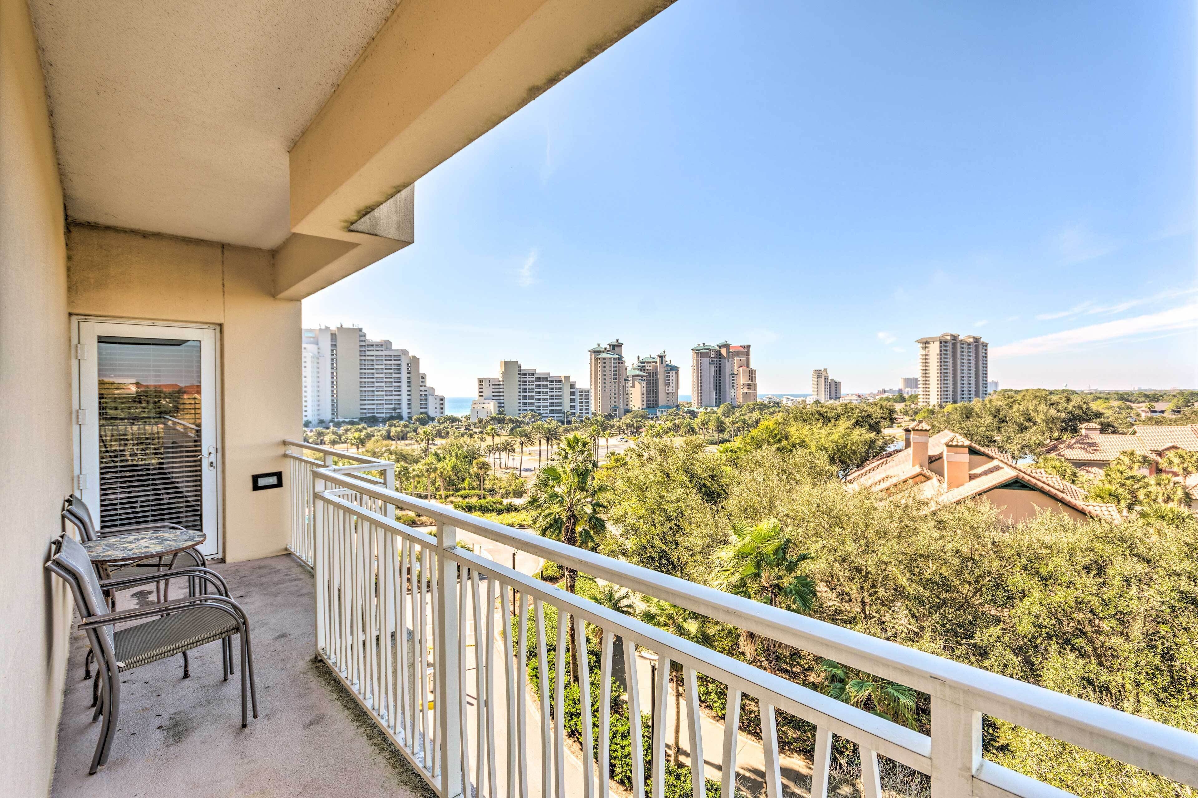 Varanda com vista para edifícios altos e um parque.