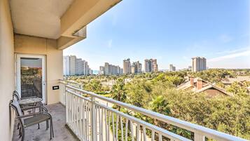 A balcony with a view of high-rise buildings and a park.