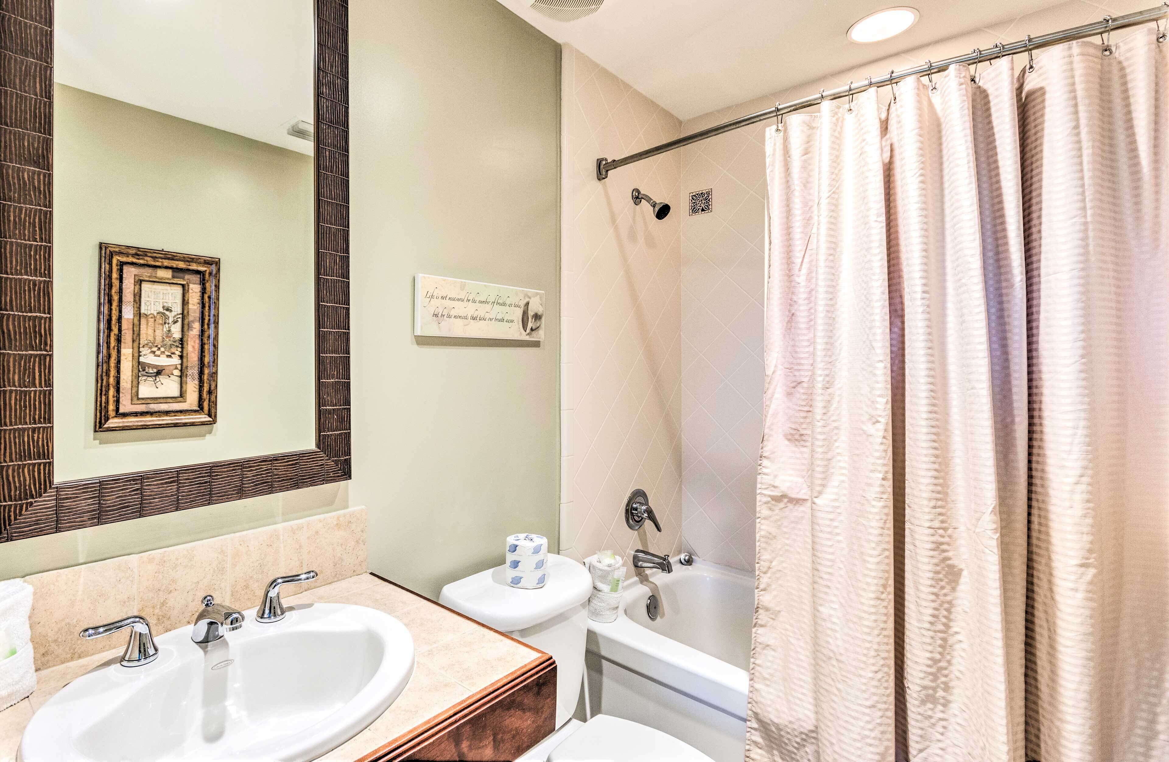 A bathroom with two sinks, a toilet, a bathtub, and a shower curtain.