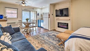 A cozy living room with a sofa, a coffee table, and a fireplace. - Balcony + Pool Access! Couples Escape in Lake Lure (Lake Lure)