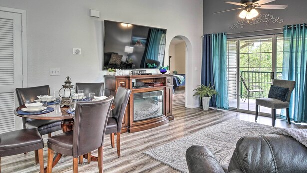 Un comedor con mesa de madera, sillas y televisor.