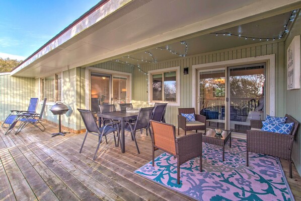 An outdoor patio with a dining table, chairs, and a seating area.