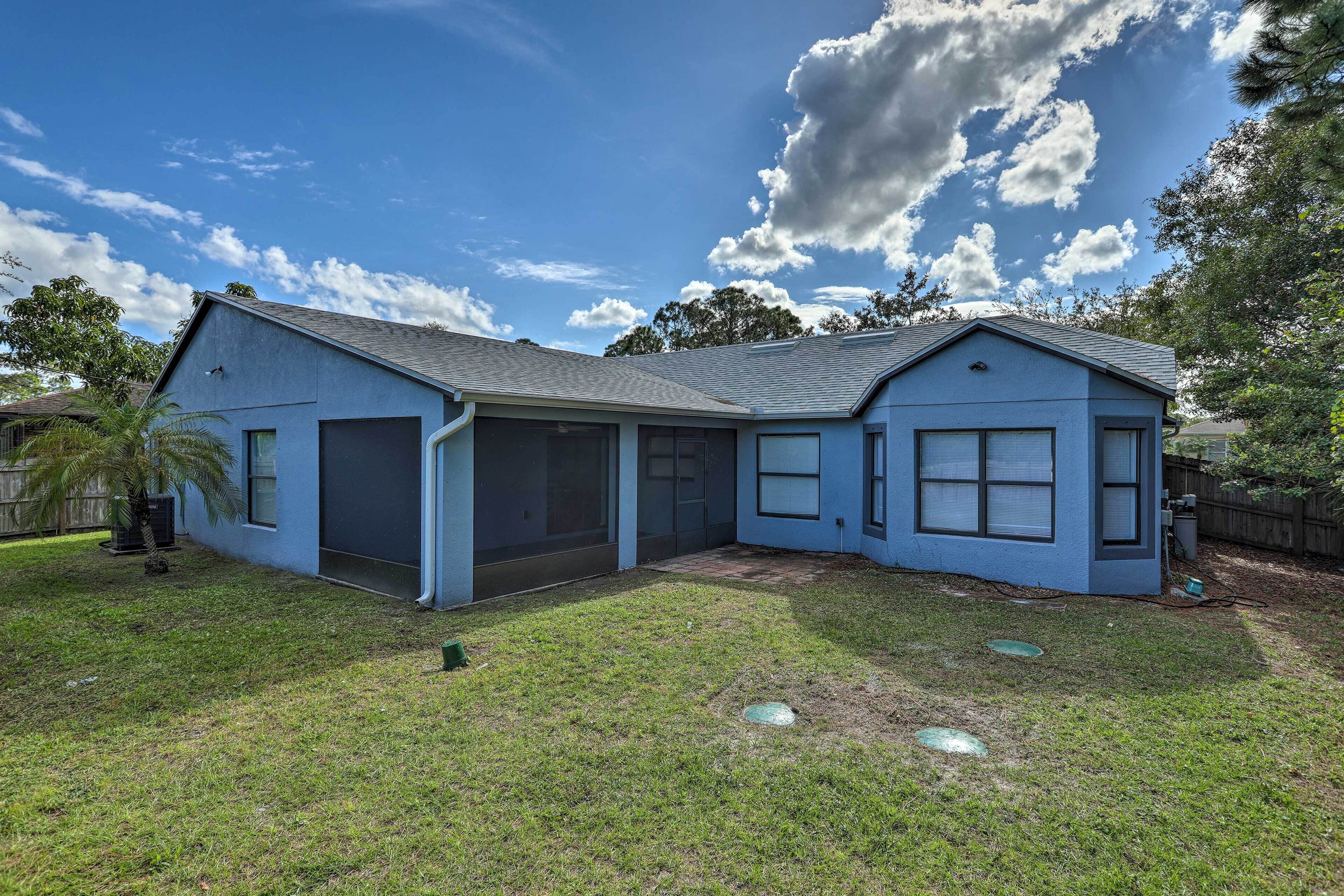 A single-story house with a garage, a covered patio, and a well-maintained lawn.