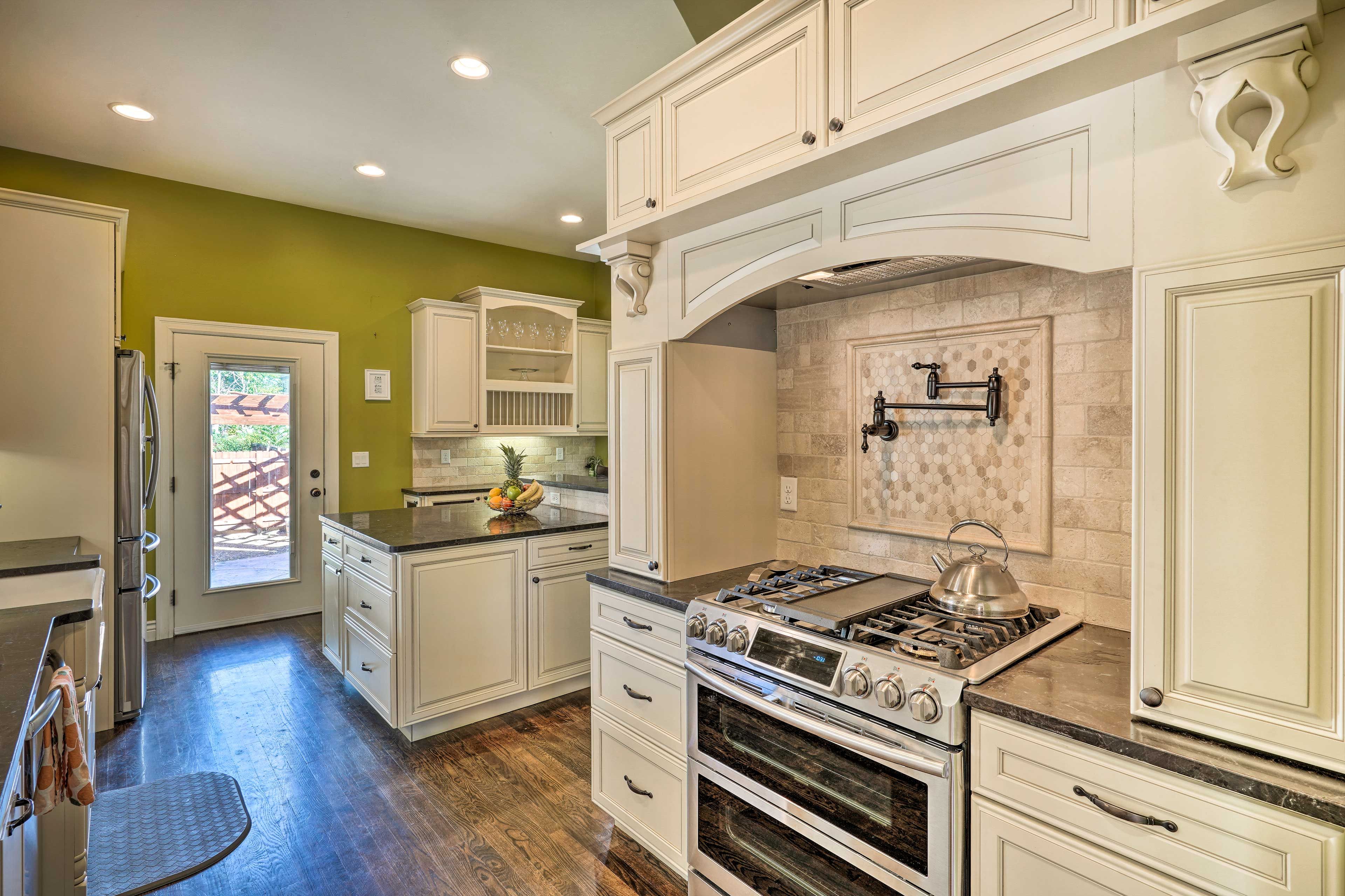 A kitchen with white cabinets, a gas stove, and a tiled backsplash.