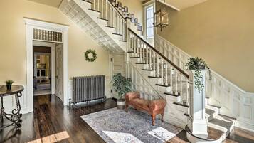 A grand staircase with white balusters and a patterned rug on the floor.